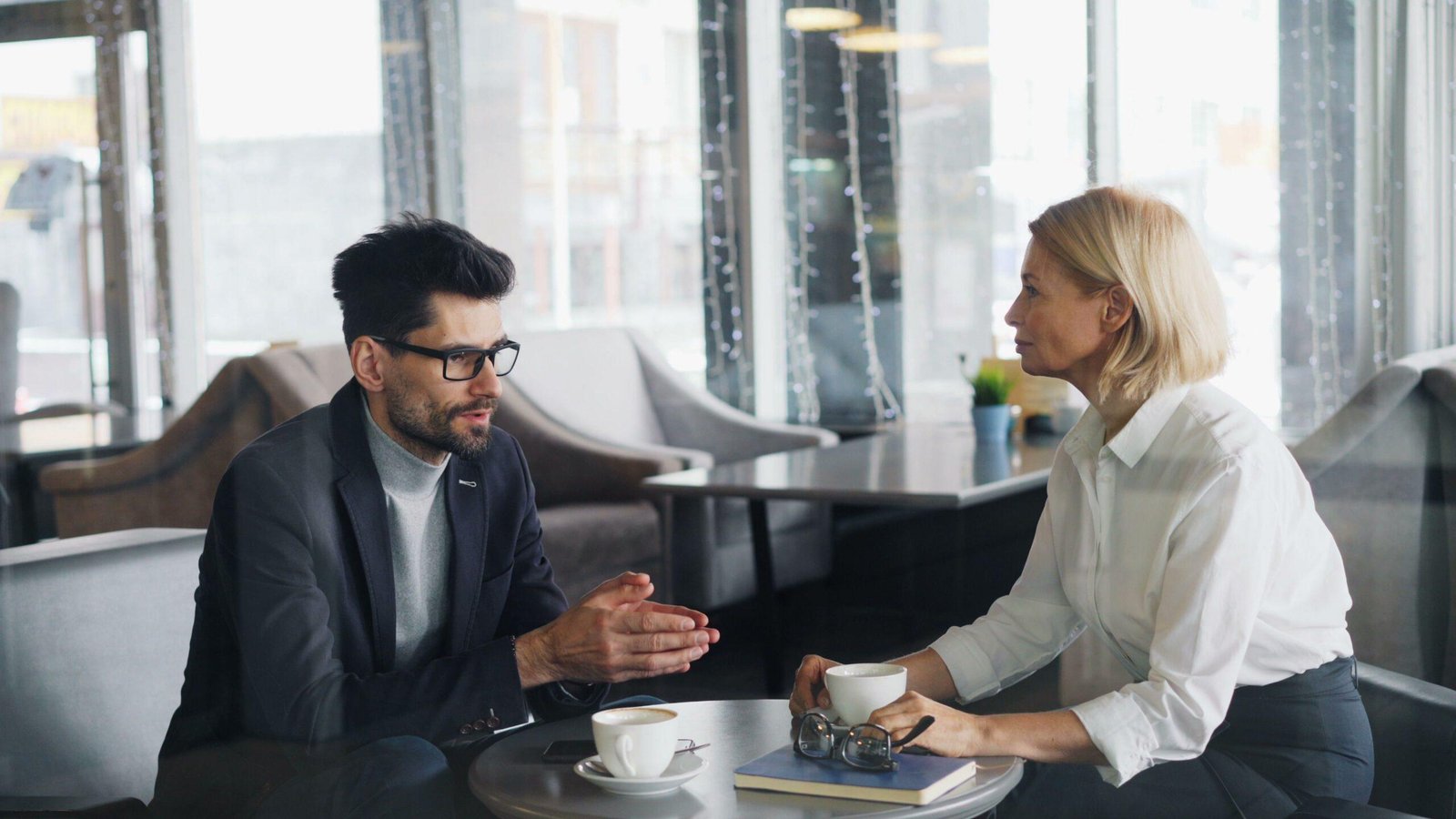 A man and a woman sit around a coffee table deep in conversation.